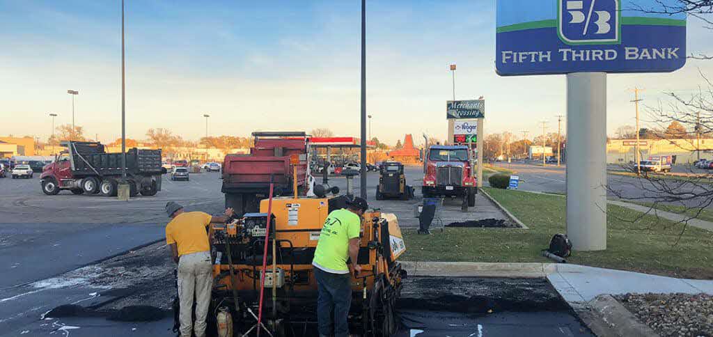 D&J Asphalt-Fifth Third Bank Workers operating an asphalt paver in a parking lot