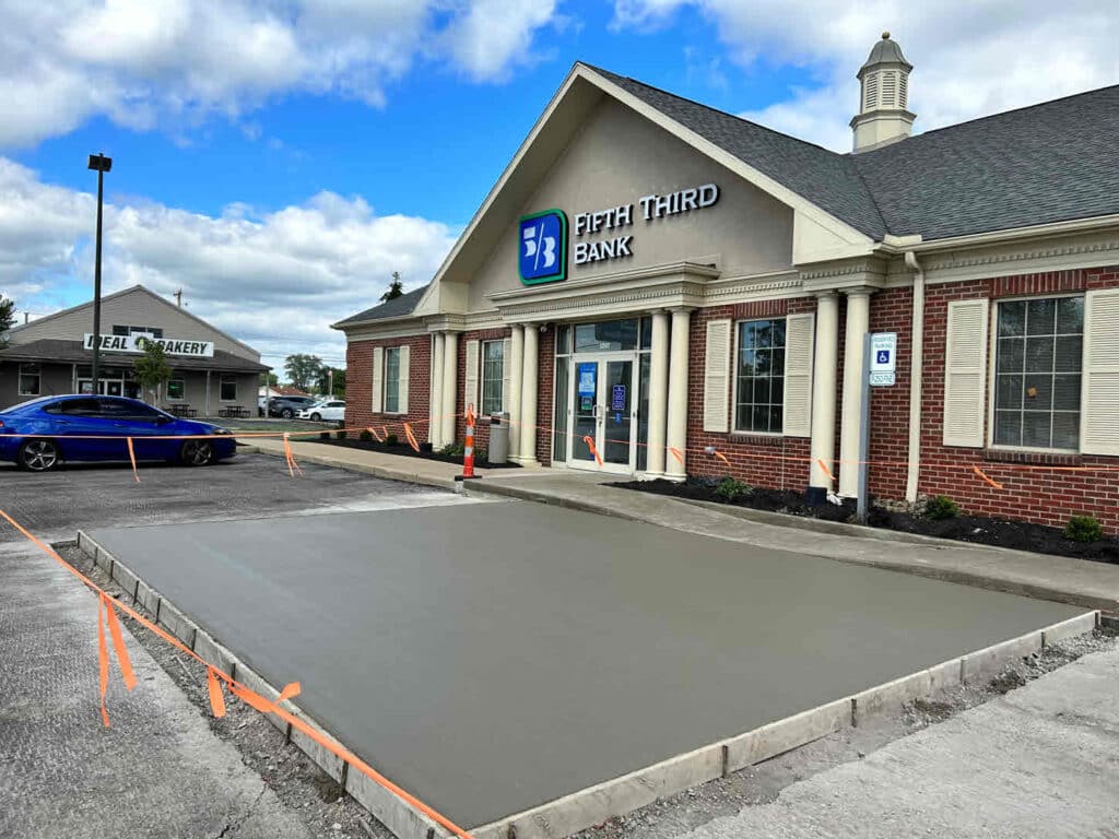 Concrete Pad Installation at Fifth Third Bank Newly poured concrete pad in a bank parking lot with wooden forms and safety cones