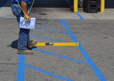 Contractor measuring an ADA-compliant accessible parking space and access aisle striping