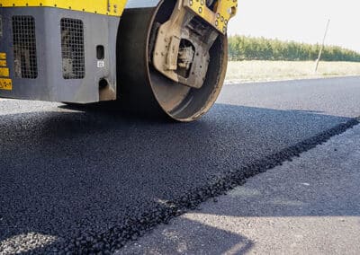 Vibratory roller compacting a fresh asphalt surface