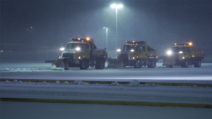 Snowplow Trucks Staging at Night Snowplow trucks parked in a snow-covered area at night