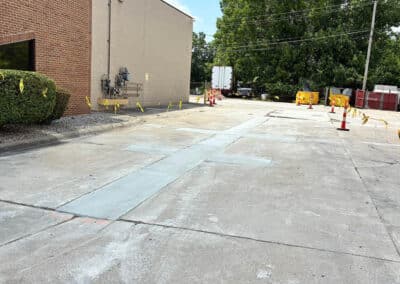 Morelli – Clinton Township, Michigan 37 Concrete lot with light blue markings and caution tape beside a brick building