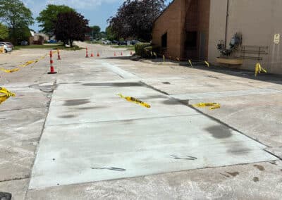 Morelli – Clinton Township, Michigan 36 Freshly paved concrete patch in a parking lot with traffic cones and caution tape