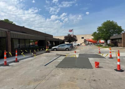 Morelli – Clinton Township, Michigan 33 Fresh asphalt surface being poured in a parking lot beside a commercial building
