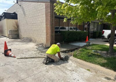 Morelli – Clinton Township, Michigan 31 Construction worker smoothing wet concrete in a trench beside a storefront