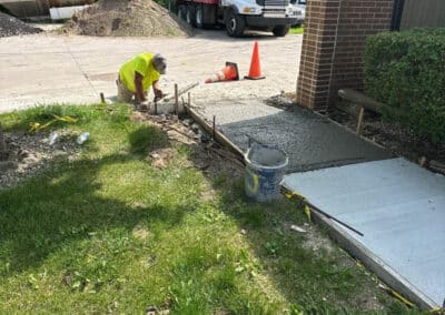 Morelli – Clinton Township, Michigan 30 Construction worker kneeling near concrete form with exposed rebar and fresh concrete