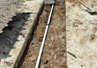 Morelli – Clinton Township, Michigan 21 Trench installation for site drainage beside a brick building