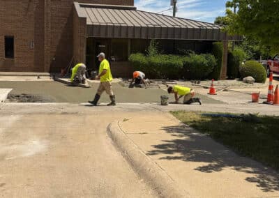 Morelli – Clinton Township, Michigan 20 Workers spreading and smoothing wet concrete on a sidewalk