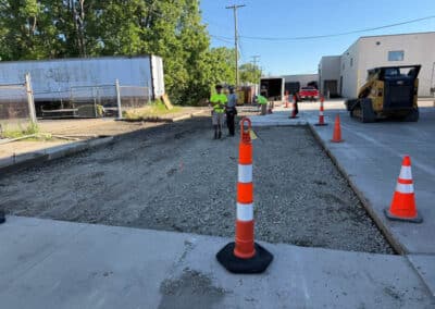 Morelli – Clinton Township, Michigan 16 Workers performing construction on a street with a gravel center and concrete curb in an industrial area